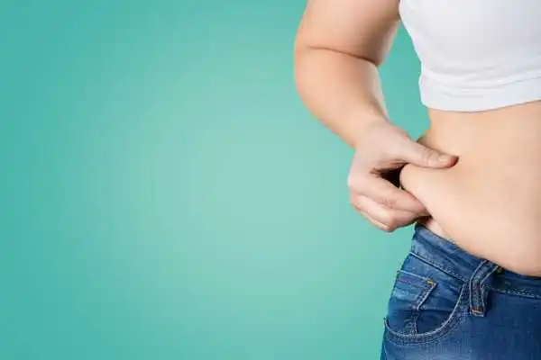Image of woman pinching her love handles to show weight gain Southampton